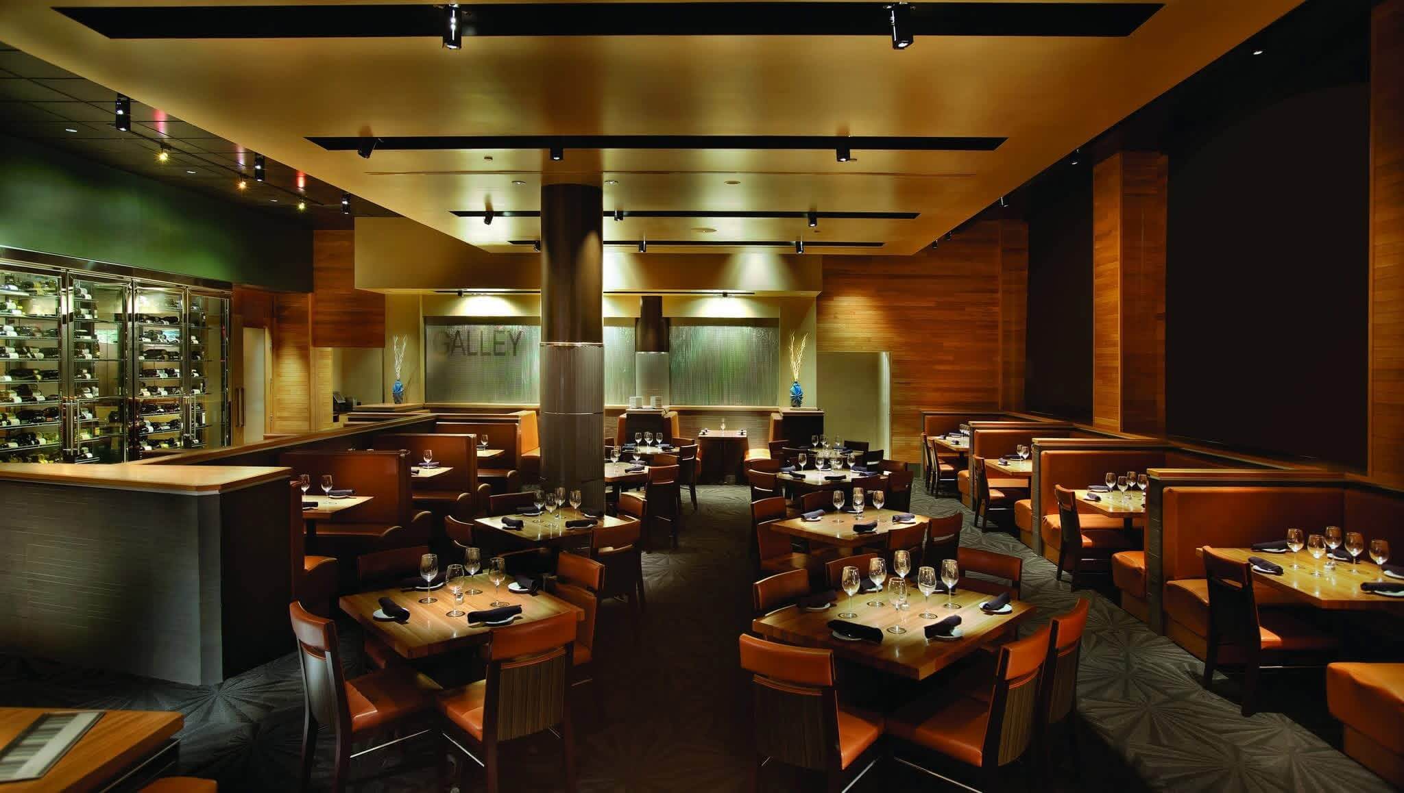 Stylish restaurant interior featuring wooden accents, elegant tables, and a wine display.