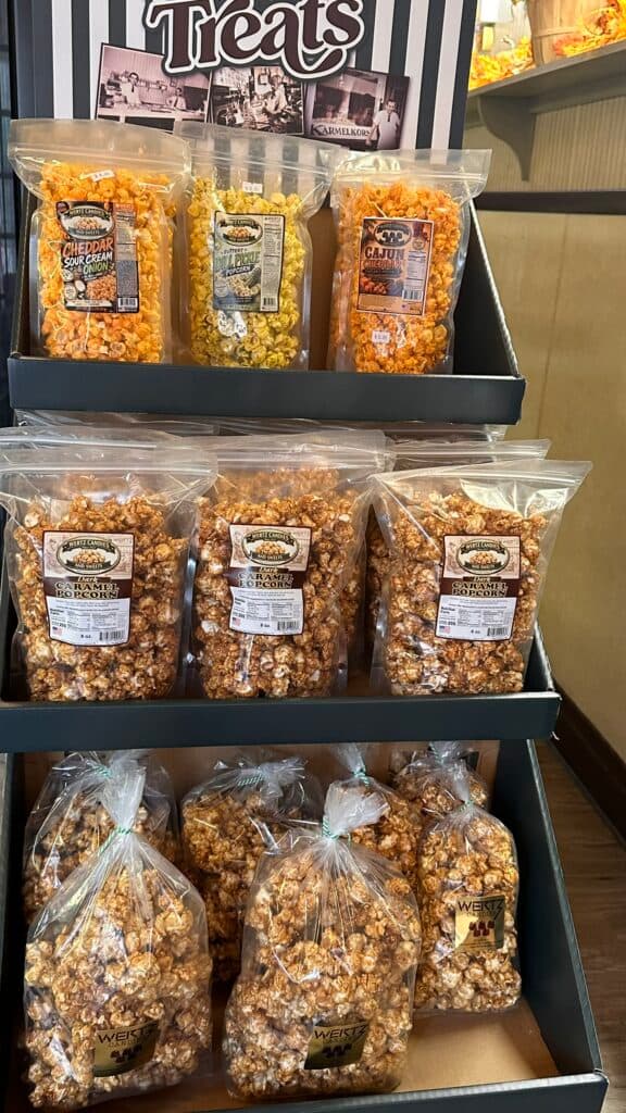 A display of various flavored popcorn bags, including cheddar, caramel, and cajun.
