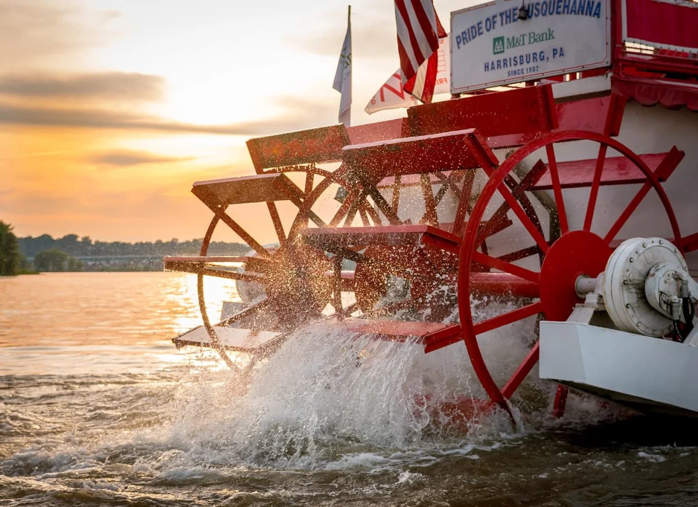 The paddlewheel of the riverboat "Pride of the Susquehanna" splashes water against the backdrop of a sunset.