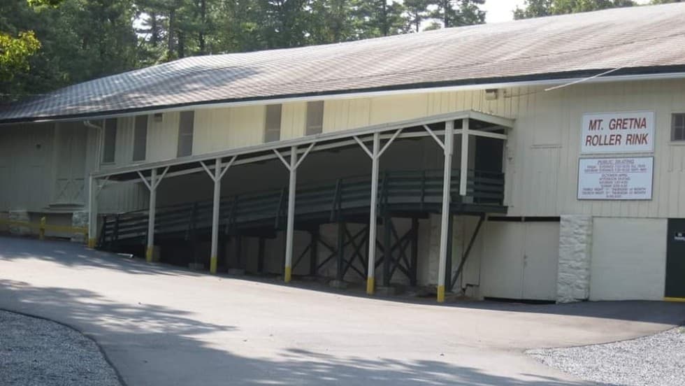 Exterior view of the Mt. Gretna Roller Rink, featuring a sloped entrance and a sign above the door.