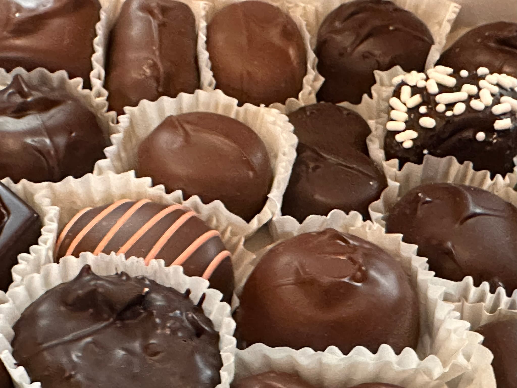 An assortment of assorted chocolate candies in paper cups.