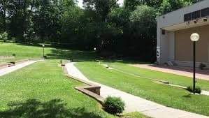 A landscaped area with pathways and a stage in a park.