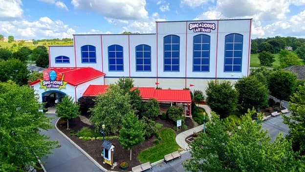 Aerial view of a colorful building labeled "Shady Acres Leaf Park" surrounded by greenery.