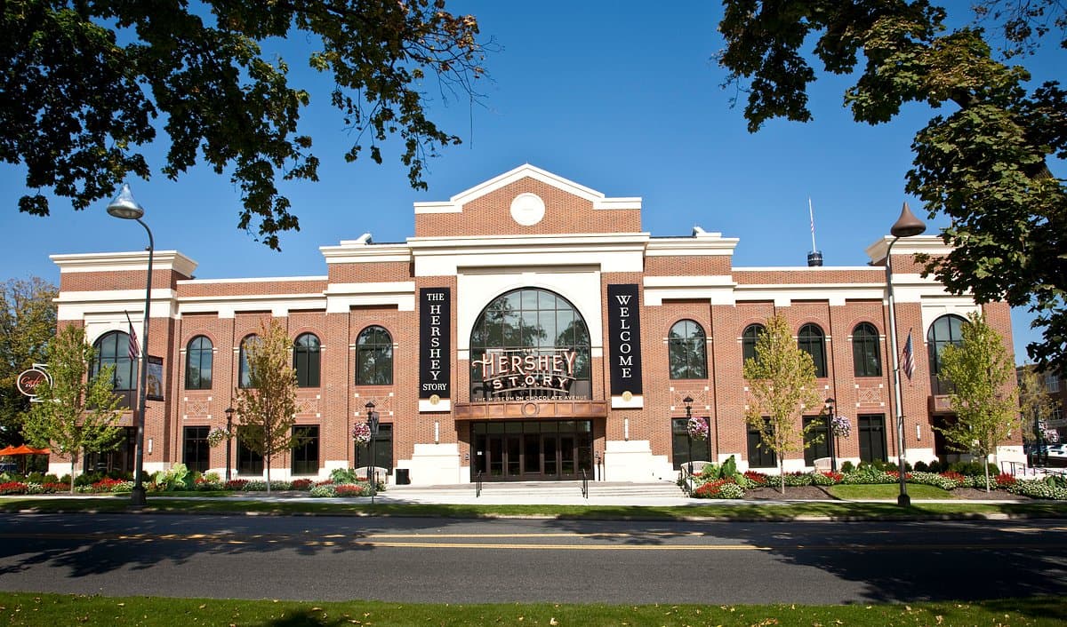 The Hershey Store features a large brick facade with prominent windows and signage against a clear blue sky.