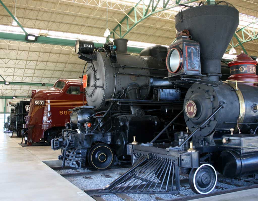 A collection of vintage steam locomotives displayed indoors.