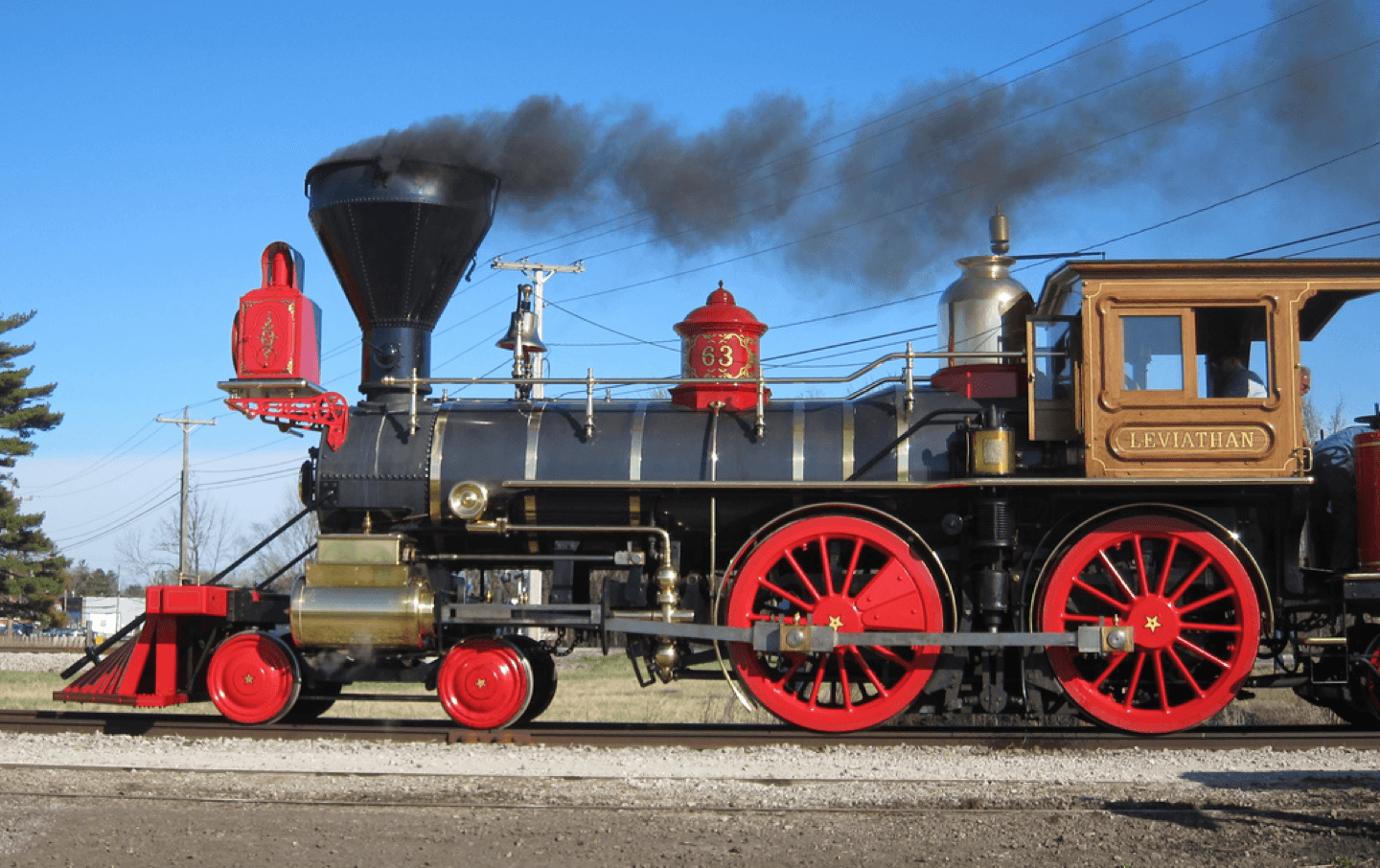 A vintage steam locomotive, named "Leviathan," billows smoke against a blue sky.