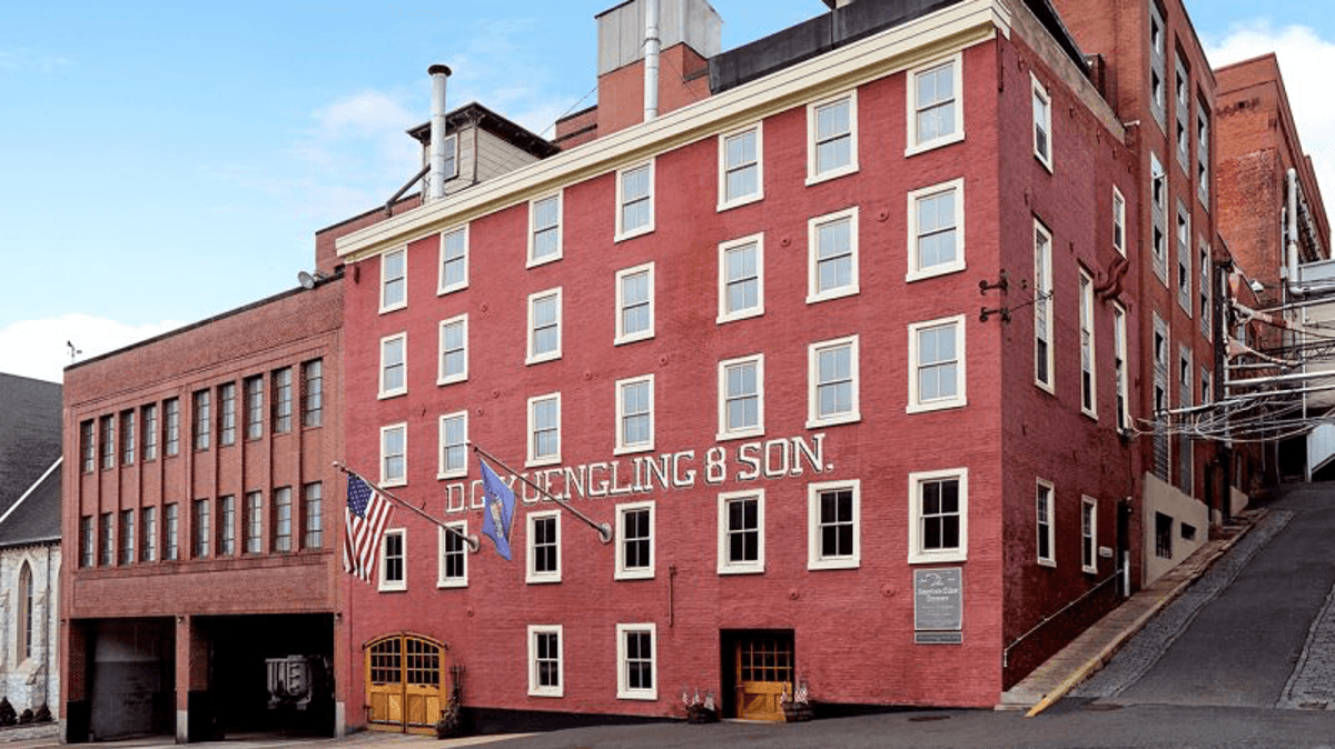 Red brick building with "D.G. Yuengling & Son" sign and two flags outside.