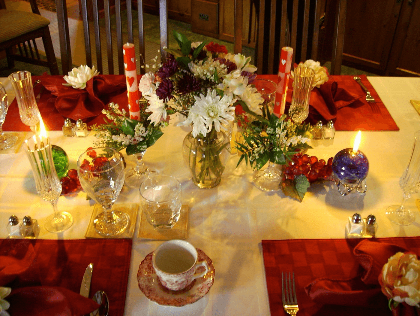 A beautifully arranged dining table adorned with flowers, candles, and elegant tableware.
