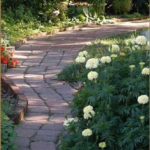 Pathway in Romance Garden. Winding pavers of red stone and lush plantings on either side.