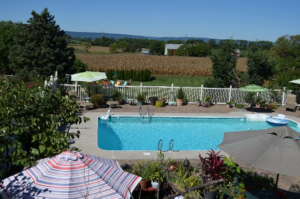 Swimming Pool with farms and mountains in background.