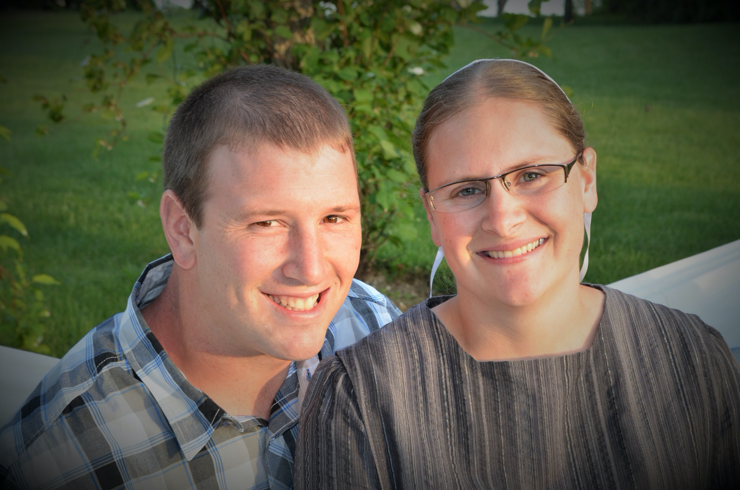 Professional portrait of young Mennonite couple outdoors.