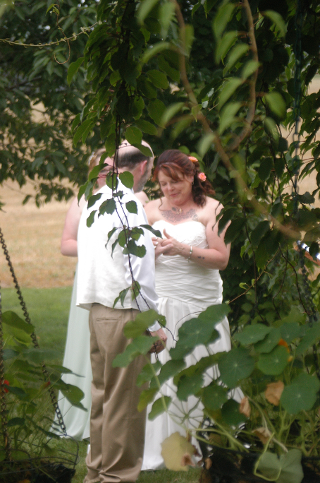 Bride and groom exchanging rings at outdoor wedding in the Pergola Garden