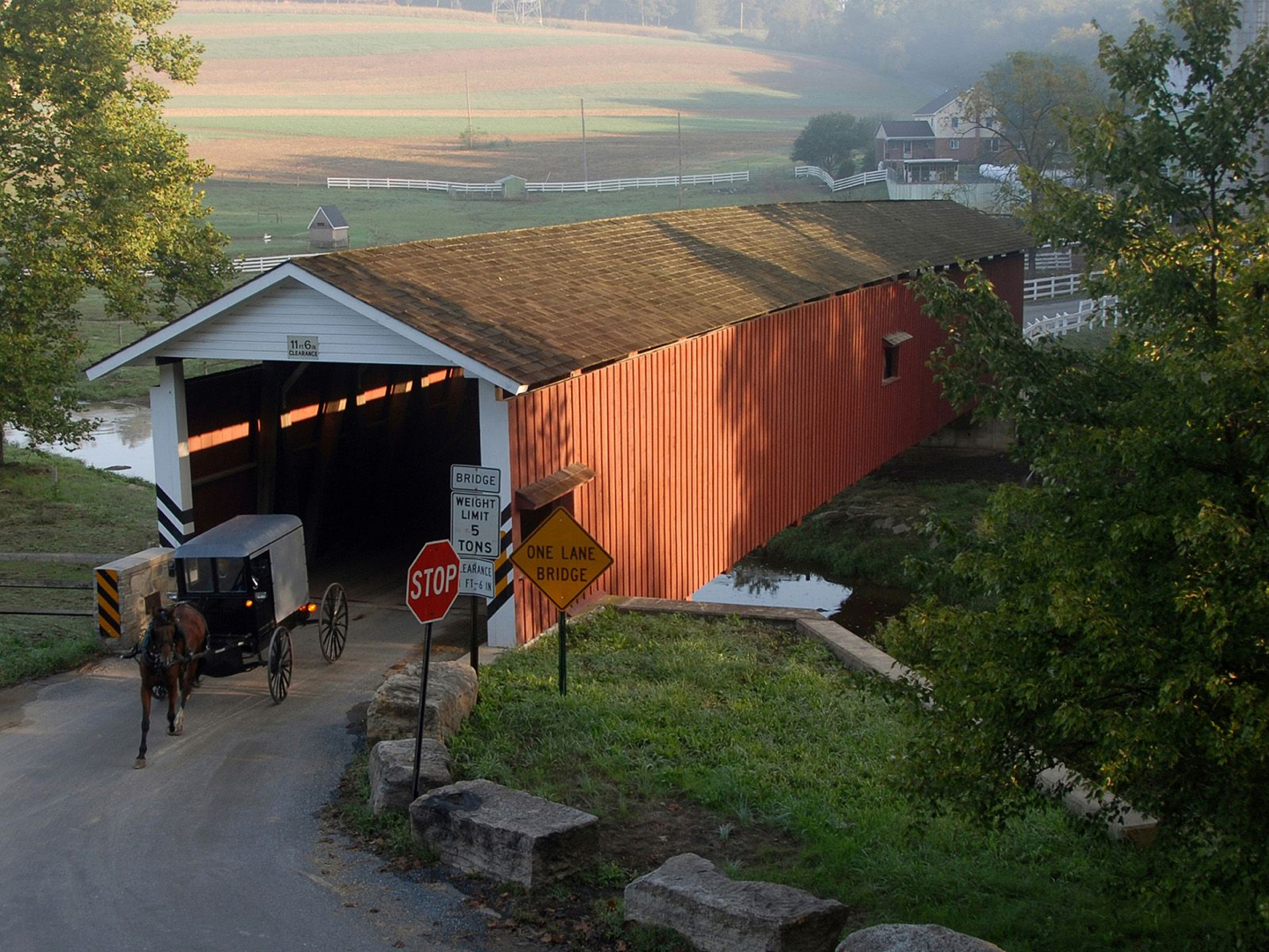 Amish buggy exiting a lng covered bridge