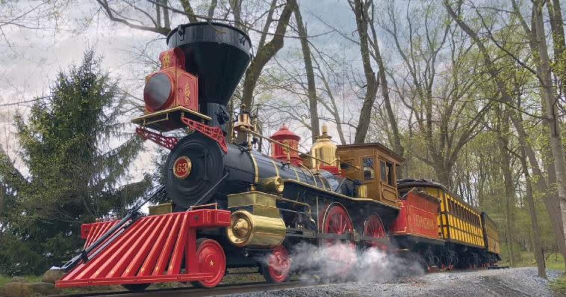 Red, Black and Shiny Brass steam locomotive, replica of Lincoln's funeral train steams through Pennsylvania woods