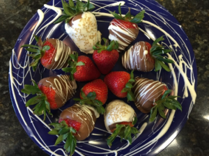 platter of chocolate covered and decorated strawberries