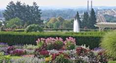 A rose garden with a tall fountain in the midground, and the  (no longer used) smokestacks of the Hershey Chocolate factory in the background.
