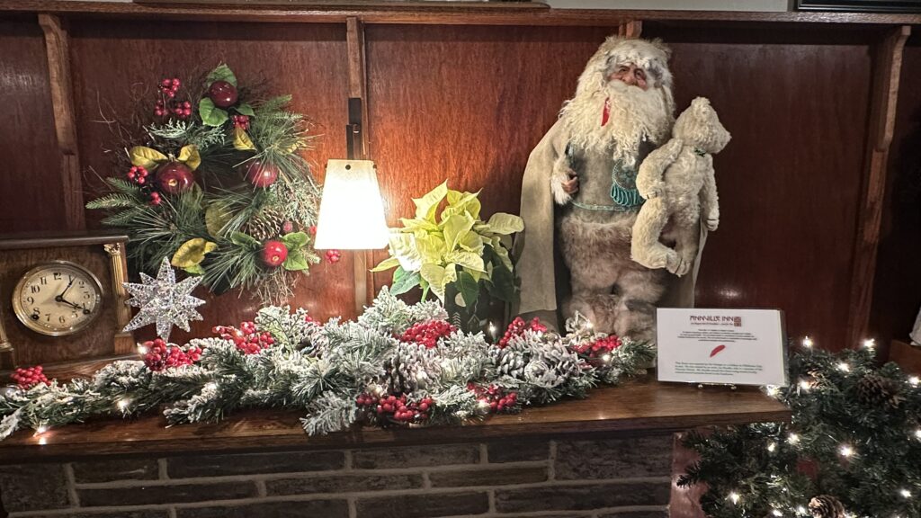 Fireplace decorated for Christmas. Christmas garland and Native American Santa Claus.