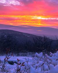 Photo of a sunset on a mountain in winter.