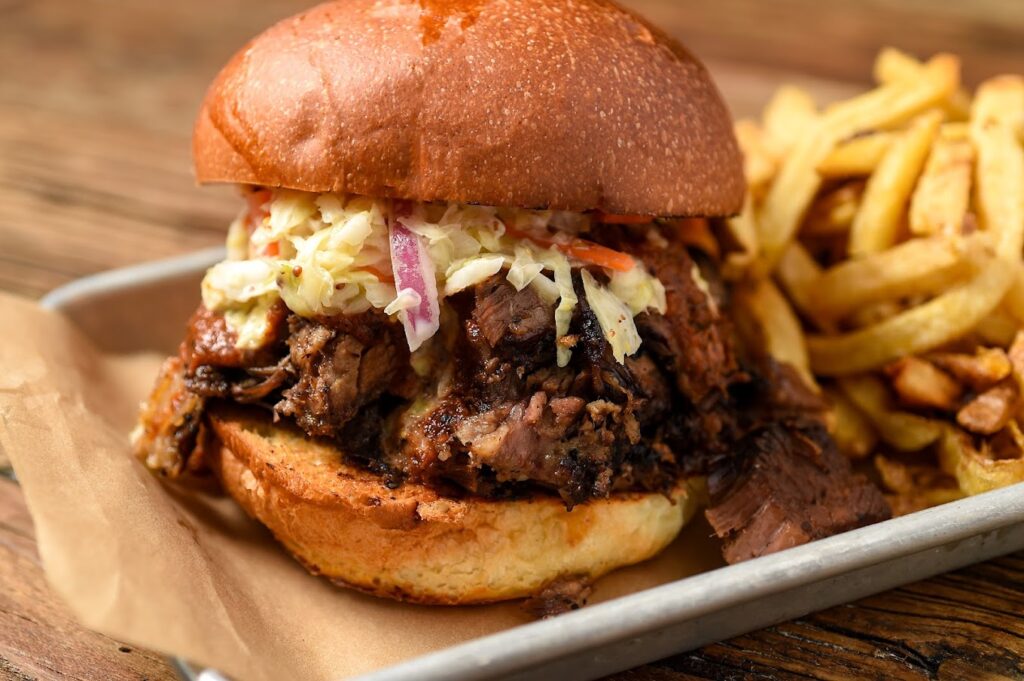 food photo. This image shows bbq on a toasted bun with cole slaw.