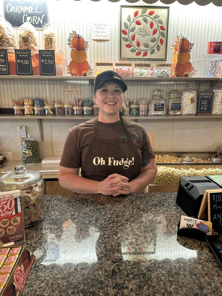 Missy; one of the owners of Wertz Candies standing behind a counter.